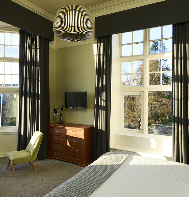 Bedroom with double bed, big windows, and places to sit